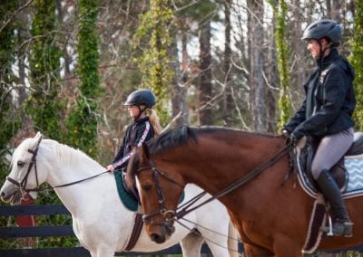 Riders enjoying a scenic trail ride through the forest at Millstone Stables.